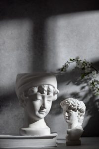 duas esculturas de busto, uma feminina e outra masculina